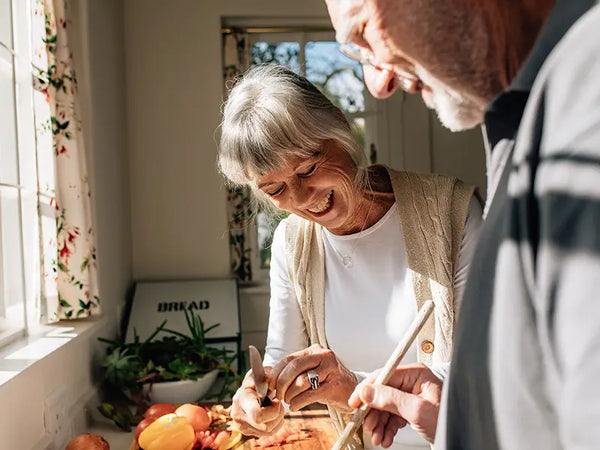 älteres Paar kocht gemeinsam und lacht